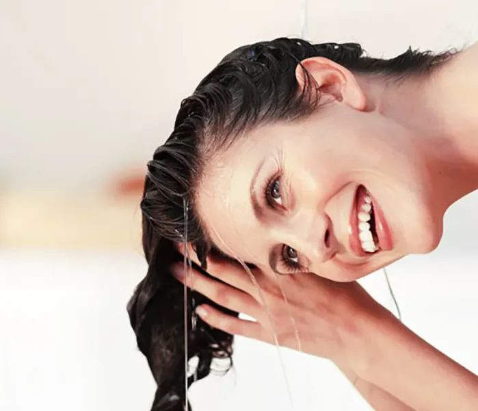 نحوه استفاده از شامپو ضد شوره برای موهای چرب(تصویر خانمی در حال شستن موها)